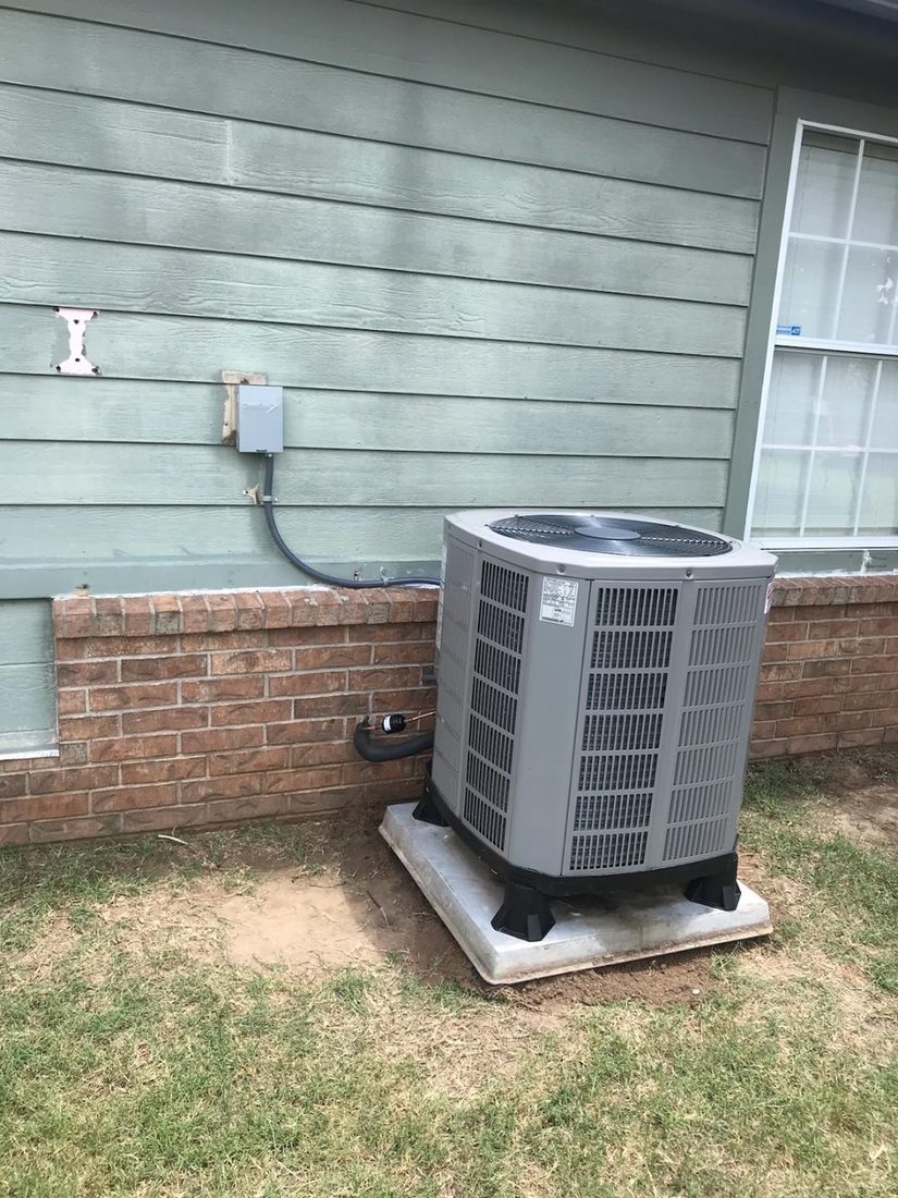 New American Standard condenser installed on a poured pad behind a Tulsa home